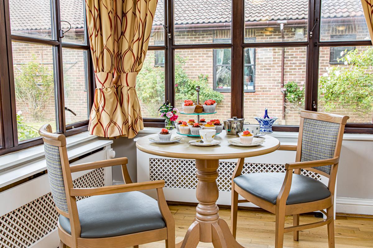 dining table with cupcakes and tea by a window